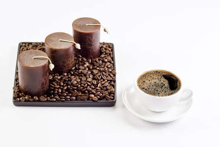 Cup of coffee with coffee beans and candlesの写真素材