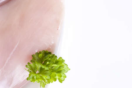 Raw chicken breast on the plate with parsley - isolatedの写真素材