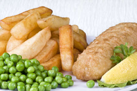 Fried fish and chips with lemon and peasの写真素材
