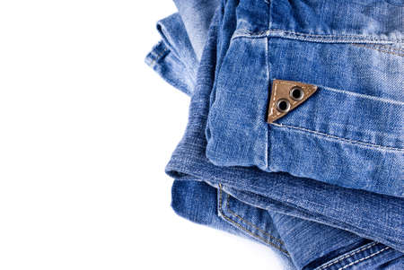 stack of various shades of blue jeans over white backgroundの写真素材