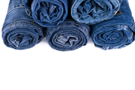 stack of various shades of blue jeans over white backgroundの写真素材