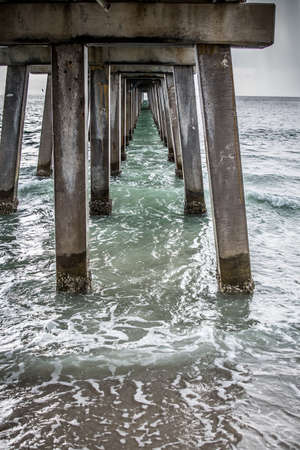 a view under the pier looking out under the supportsの写真素材