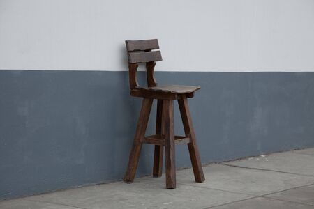 Wooden stool sitting on the sidewalkの写真素材
