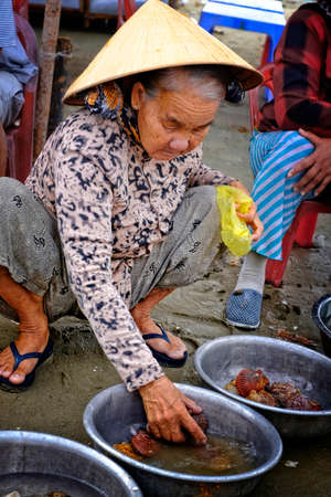 Vietnamese woman selling fish on the beach.のeditorial素材