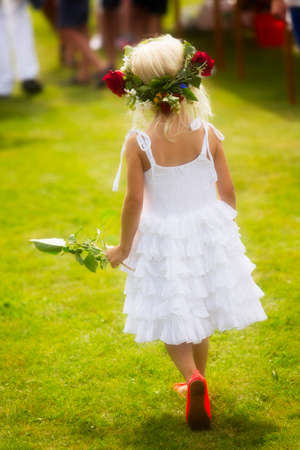 Midsummer Eve with a little girl wearing white with wreath in her hair.の写真素材