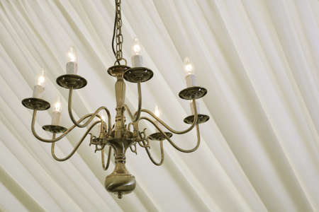 chandelier hanging in a marquee under cream silk