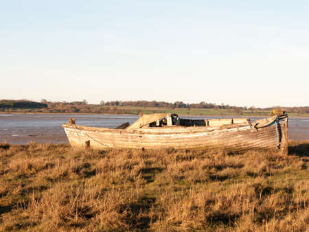 A boat standing stationary in the in mud with the tide out