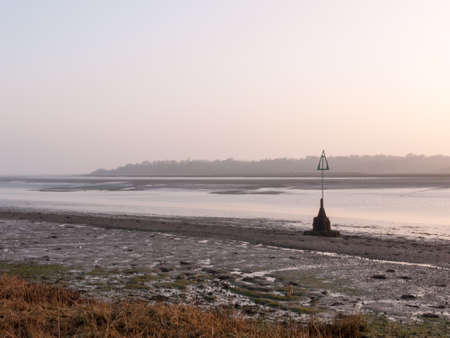 Various shots of the river and the mud, along with many birds, buoys, and other sea structures, as the sun setsの写真素材