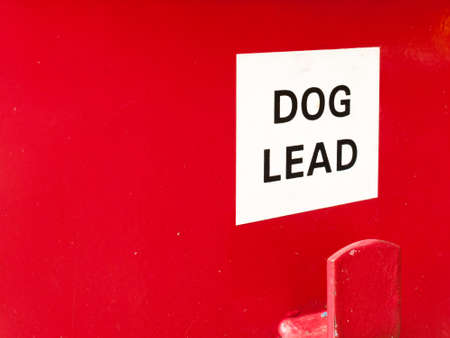a white and red sign saying dog lead on a red bin box for litter clean nature environment animalsの写真素材