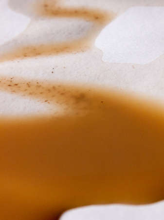 close up macro of a coffee stain on a white background swirlの写真素材