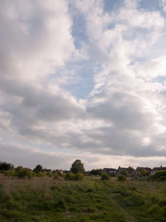scene of countryside outside with clouds and path through the country to walk landscape peace in spring late afternoonの写真素材