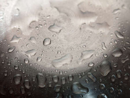 Water droplets on a shiny metal surfaceの写真素材