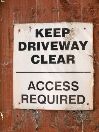 keep driveway clear access required parking sign on wooden shed garden wallの写真素材