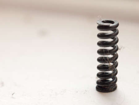a small black coil spring on whiteの写真素材