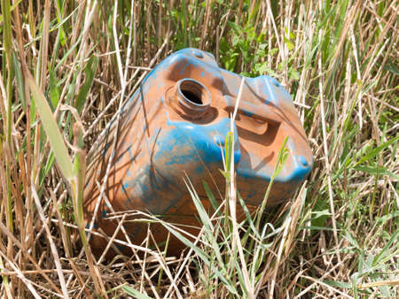 a discarded and rusted oil tank in the reedsの写真素材