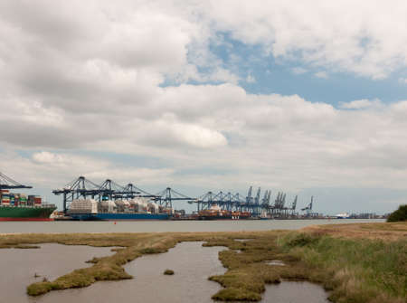 blue sea structure cranes at cargo dock loading in distance felixstowe essexのeditorial素材