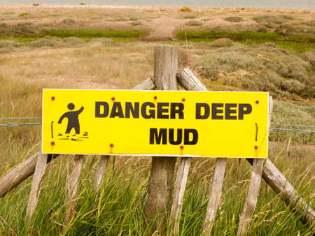 a danger deep mud yellow rectangle sign outside sea coast