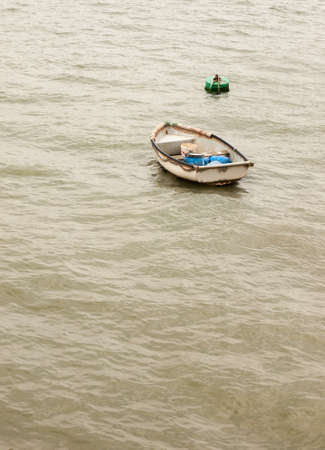a single wooden boat no people in a grey sea alone