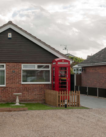red uk telephone box outside of house; UKの写真素材