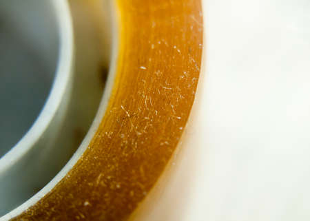 extreme close up of yellow sticker tape cellophane on white background; UK