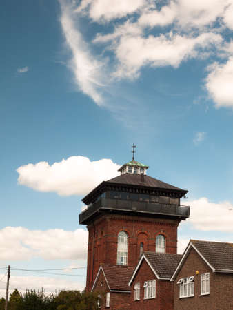 water tower turned in a house with blue sky and cloudsの写真素材
