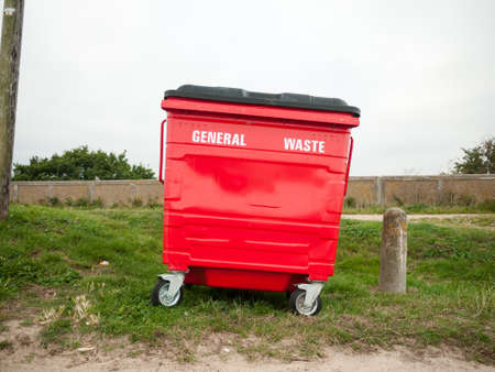 a red general waste bin single one outside on grass; England; UKの写真素材