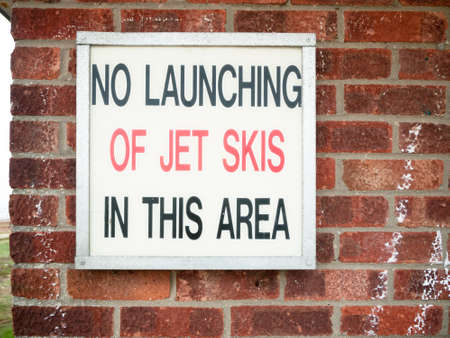 old retro sign lettering on wall saying no launching of jet skies in this area; England; UKの写真素材