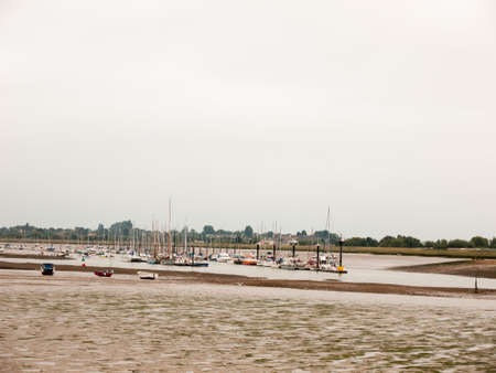 lots of moored boats parked in the river calm overcast white day; England; UKの写真素材