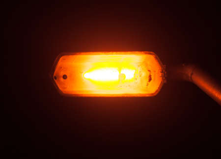A bright glowing street lamp light in the dark outside at night; Essex; England; UK