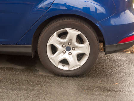 close up of back wheel rim cap blue car; England; UKの写真素材