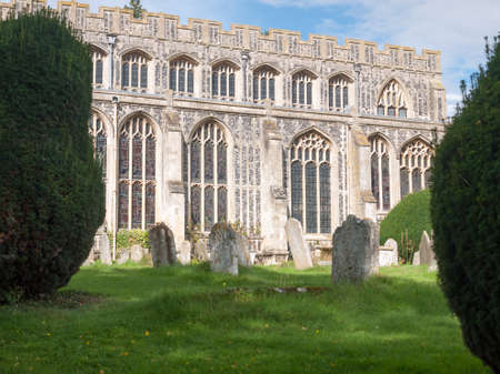 view of glasses ornate side of church hall, with graves in front; England; UKの写真素材