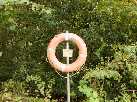 life safety buoy on metal stand post near lake; Essex; England; UKの写真素材