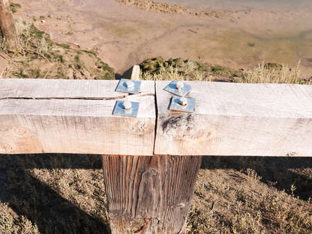 close up of four metal screw tops on wooden fence; essex; england; UK