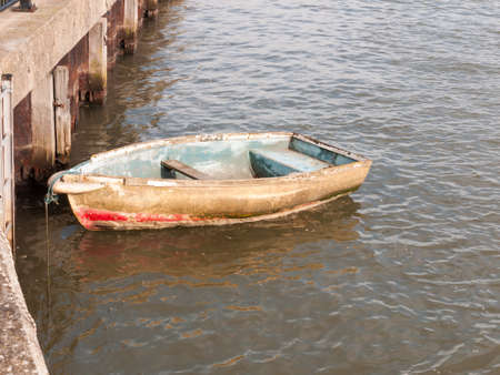wooden row boat moored in river stream; Essex; England; UKの写真素材