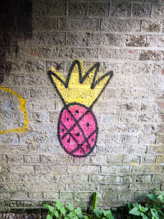 strange pink and yellow spray painted graffiti logo on underpass wallのeditorial素材