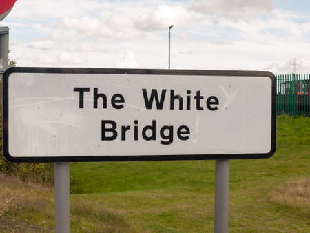 big rectangular black and white road sign the white bridge locationの写真素材