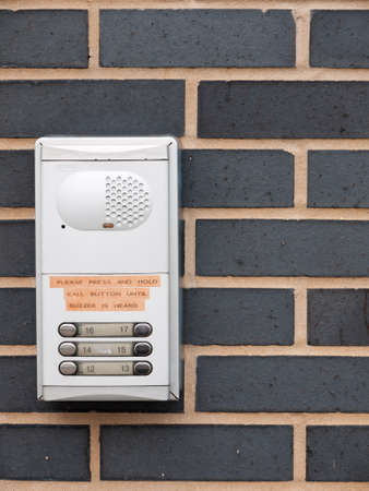 close up of metal door buzzer for apartments on wall outside; essex; england; uk