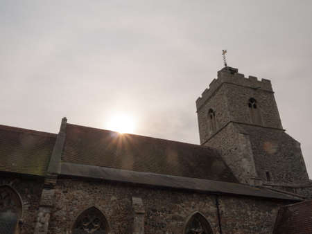 sun beam glare light orb on top of church roof sky; essex; england; ukの写真素材