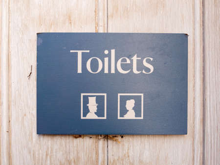 rectangle public toilets sign on door with man and woman icons; essex; england; ukの写真素材
