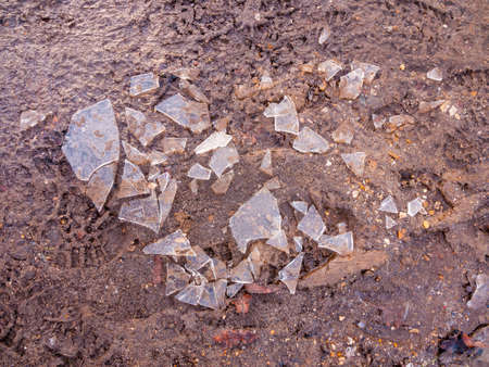 shattered broken ice on mud floor walk surface outside texture winter frost; essex; england; ukの写真素材