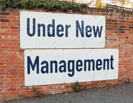 big large white and black sign on brick wall under new management; essex; england; ukの写真素材