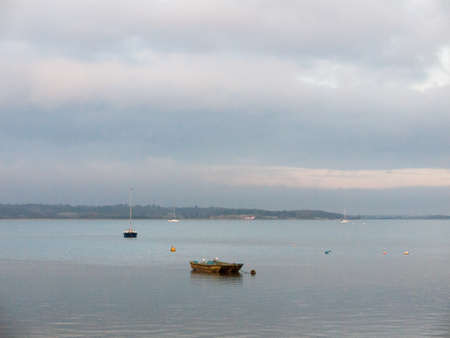 sunset over coast ocean bay water sky sea boats docks moored; essex; england; ukの写真素材