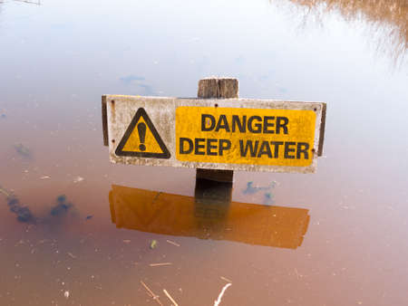 Danger deep water sign water surface careful warning yellow triangle; essex; england; ukの写真素材