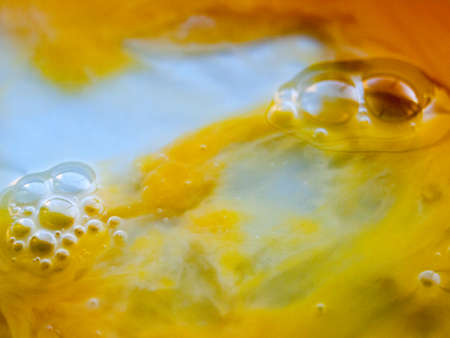 Close up egg yolk macro shot food yellow and white texture liquid bubbles; essex; england; ukの写真素材