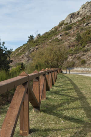 closeup of a wooden railing with the mountain out of focus in the backgroundの写真素材