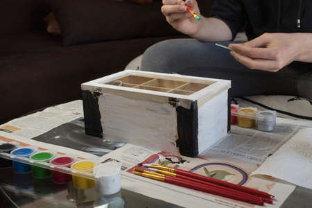 closeup of hands painting a wooden box with watercolorsの写真素材