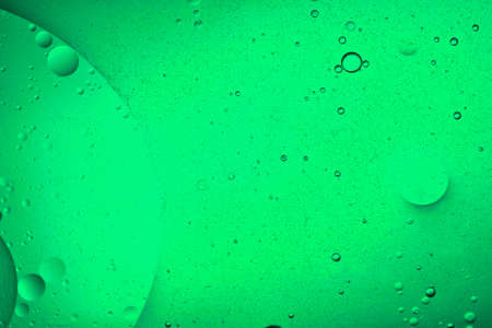 close-up view of a pastel green liquid background of moving bubbles