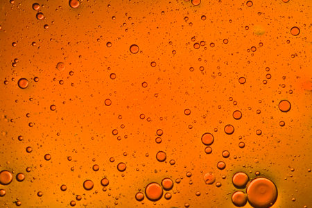 close-up view of a deep orange liquid background of moving bubblesの写真素材