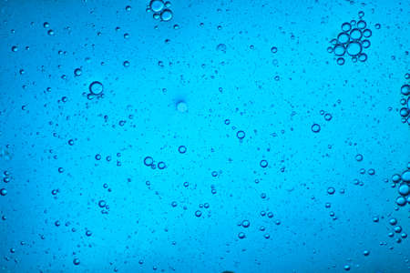 close-up view of a light blue liquid background of moving bubblesの写真素材