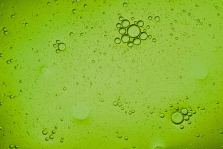 close-up view of a pistachio green liquid background of moving bubblesの写真素材